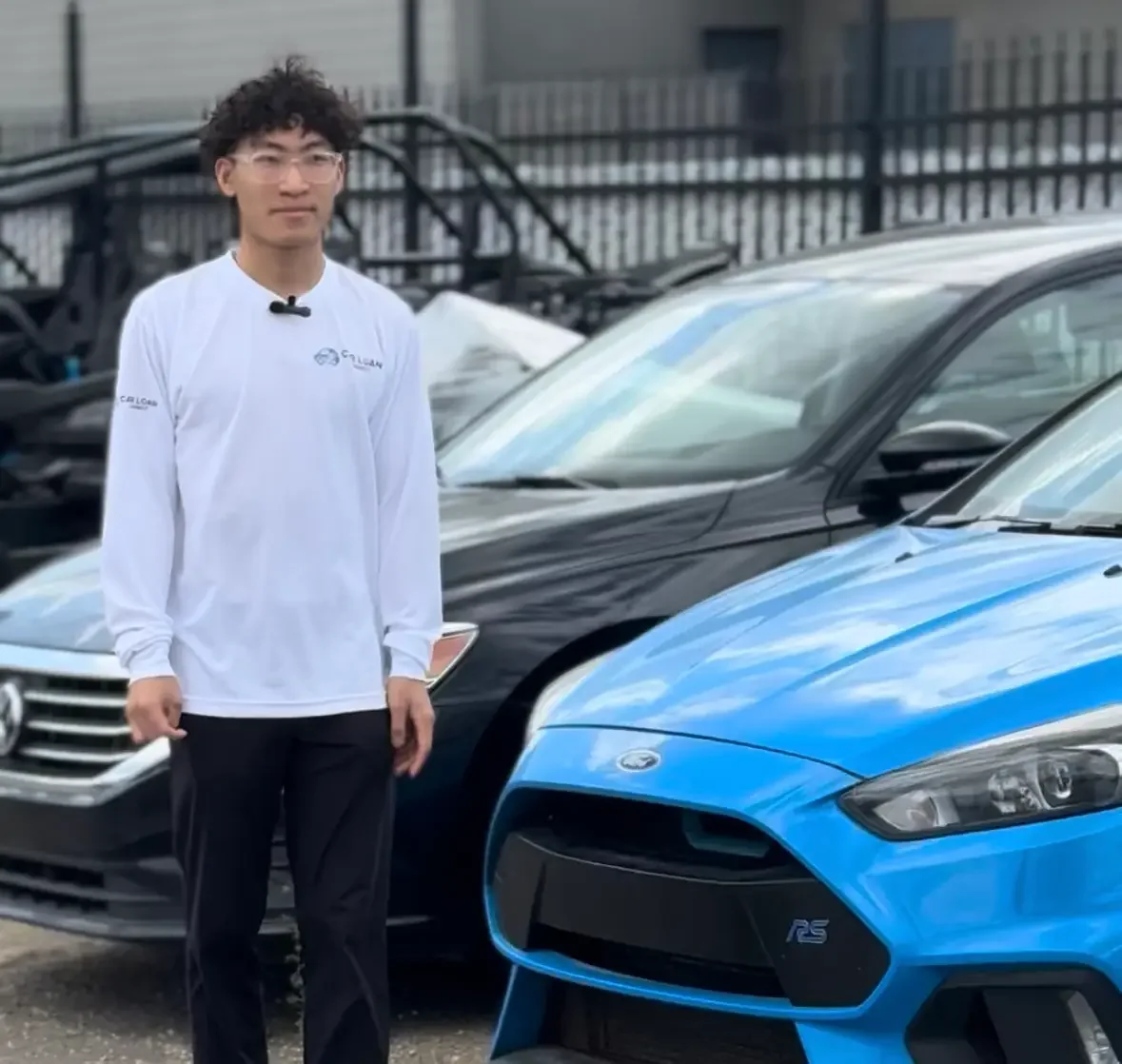 Brayden Lee standing beside vehicles on a dealership lot